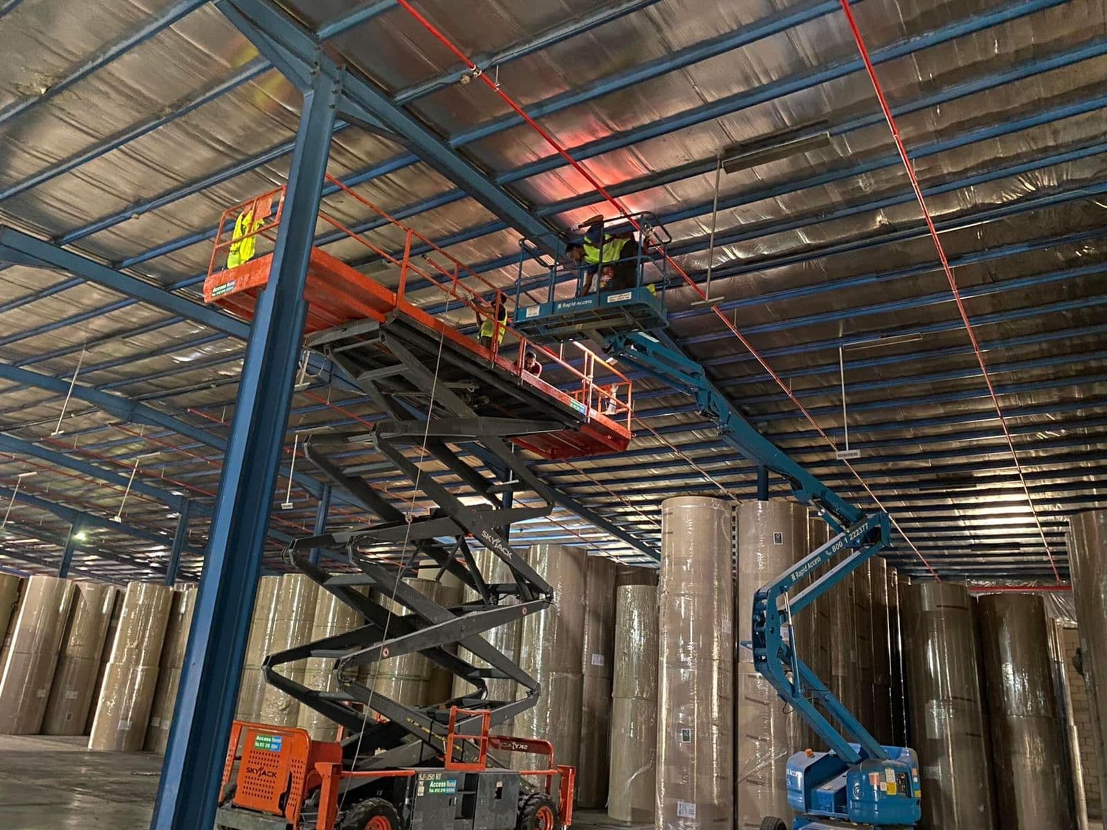 Workers on elevating machinery for fire system installation